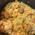 Bowl of Cajun sausage and shrimp pasta with vibrant vegetables and spices