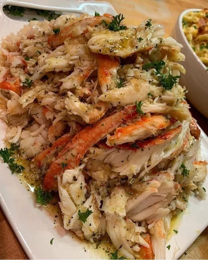 Plate of succulent Lemon Butter Crab garnished with fresh herbs and lemon slices