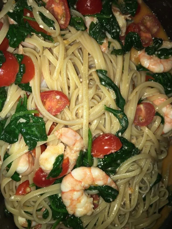 Shrimp tomato spinach pasta in garlic butter sauce served in a bowl